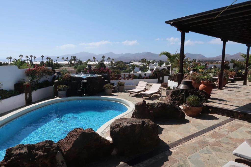 uma piscina num quintal com pedras em Finca Paraíso - Finest Villa with incredible views over Puerto del Carmen em Puerto del Carmen
