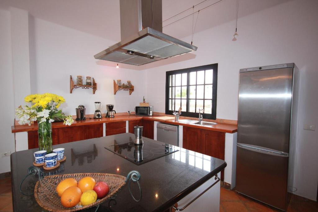 a kitchen with a stainless steel refrigerator and a bowl of fruit at Holiday home Refugio Yuco in La Vegueta in Tinguatón