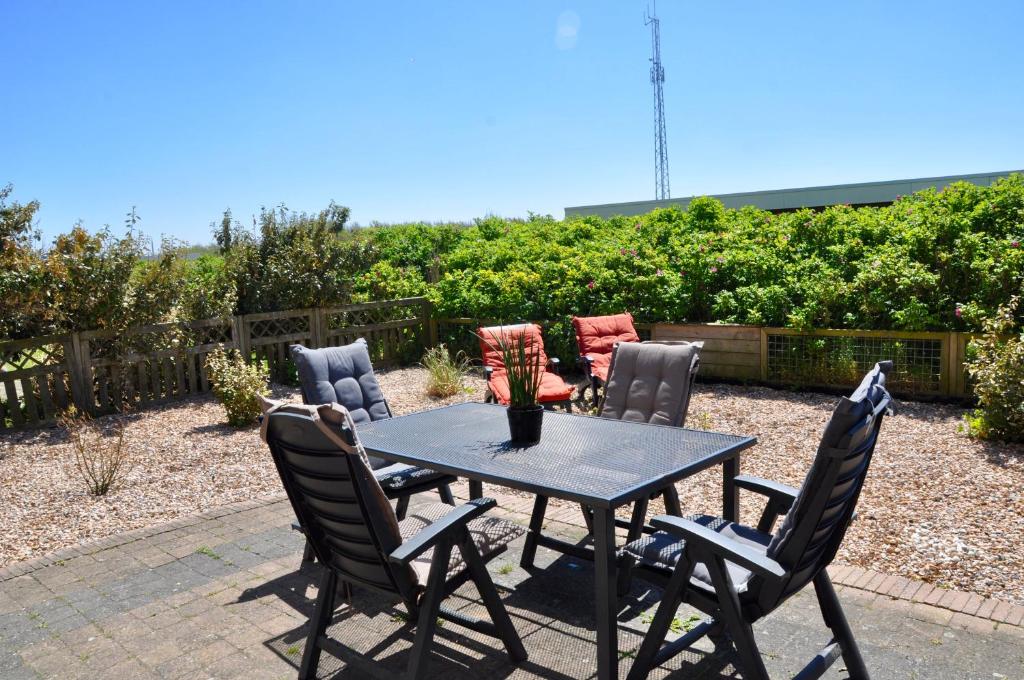 einen Tisch und Stühle auf einer Terrasse in der Unterkunft Duinerei appartement C001 in Callantsoog