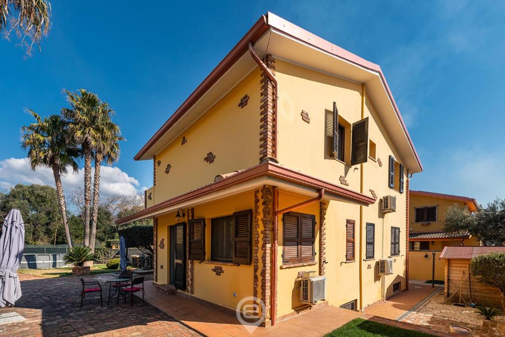 a yellow house with black shutters on it at Villa Monica Suites - Wonderful Sardinia in Iglesias