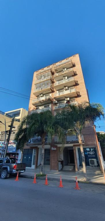 a tall building with trees and orange cones in front of it at A7A - Apartamento de 2 dormitorios con Terraza y Asador in Santiago del Estero