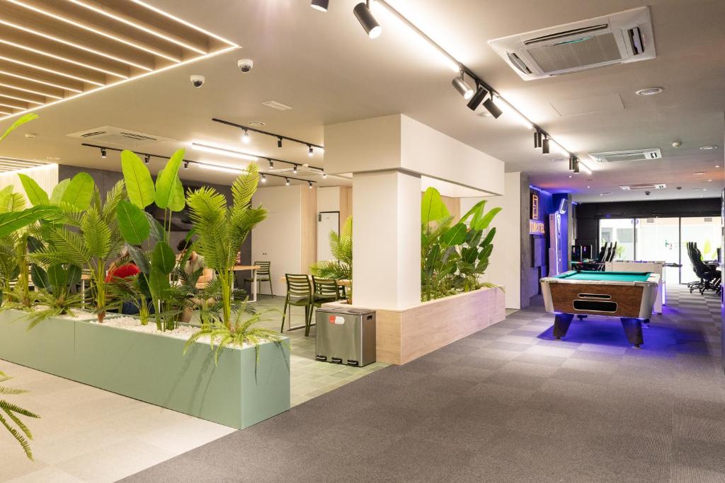 un bureau avec des plantes et un billard dans l'établissement Futurotel Malagueta Beach, à Malaga