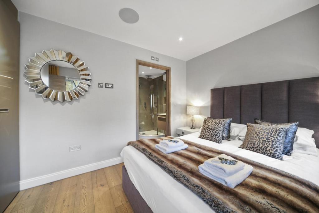 - une chambre avec un grand lit et un grand miroir dans l'établissement Lux 2 & 3 Bed Apartments in Camden Town FREE WIFI by City Stay Aparts London, à Londres
