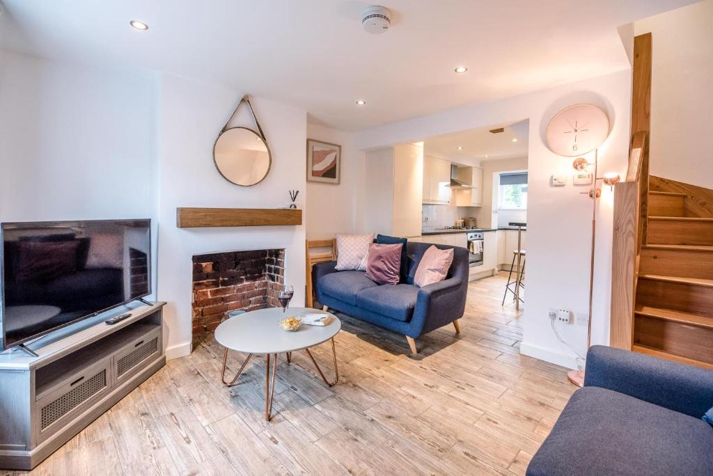uma sala de estar com um sofá, uma televisão e uma mesa em Lily Cottage Leiston em Leiston