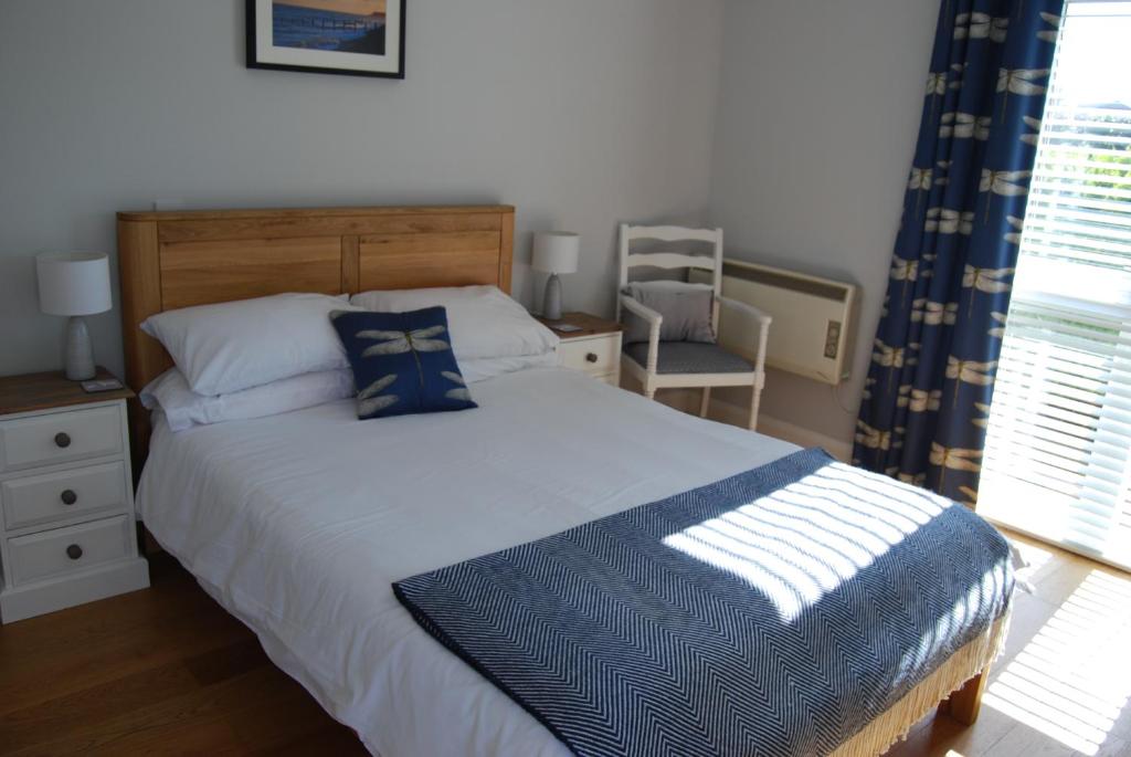 a bedroom with a bed and a chair and a window at Hare & Hounds Bed & Breakfast in Rye