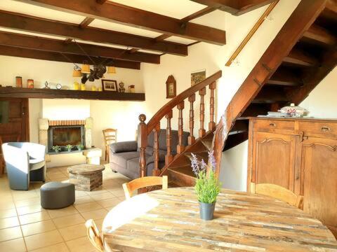 - un salon avec une table en bois et un escalier dans l'établissement Chez Tata Célestine, à Castelnau-Pégayrols