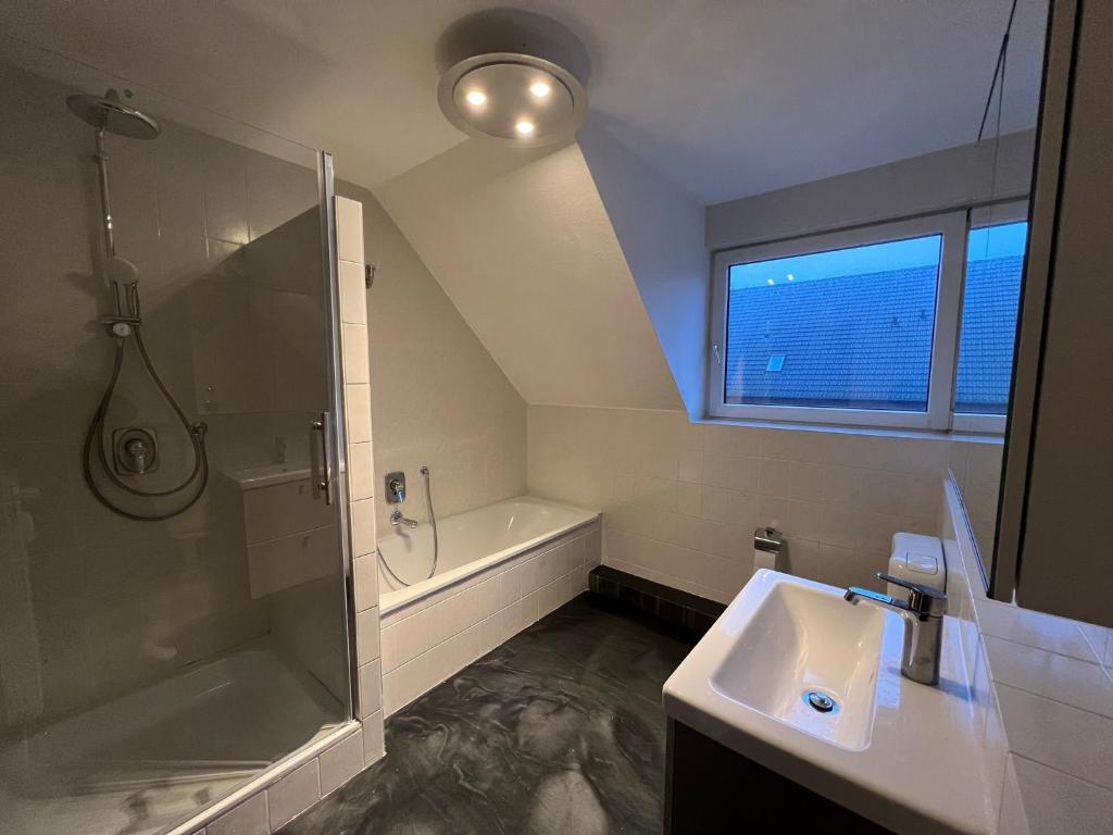 a bathroom with a sink and a shower and a tub at Isenbüttel Ferienwohnung in Isenbüttel