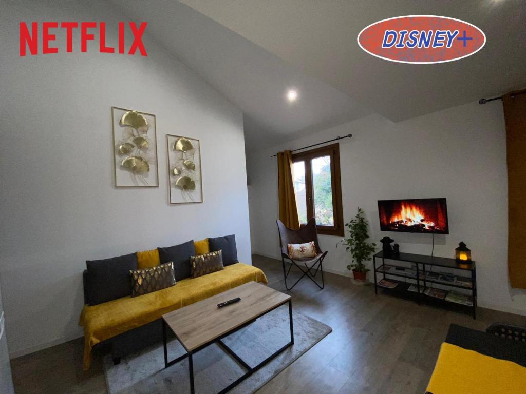 ein Wohnzimmer mit einem gelben Sofa und einem Kamin in der Unterkunft appartement au coeur de Loupiac in Loupiac-de-Cadillac