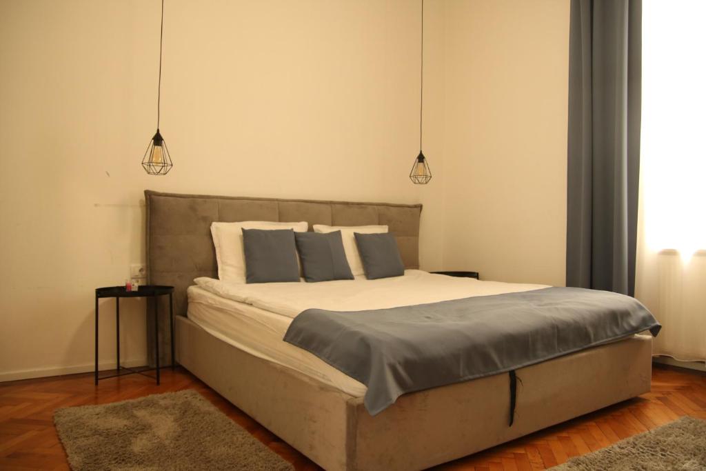 a bedroom with a large bed with two lamps at Natalie's Royal M in Belgrade