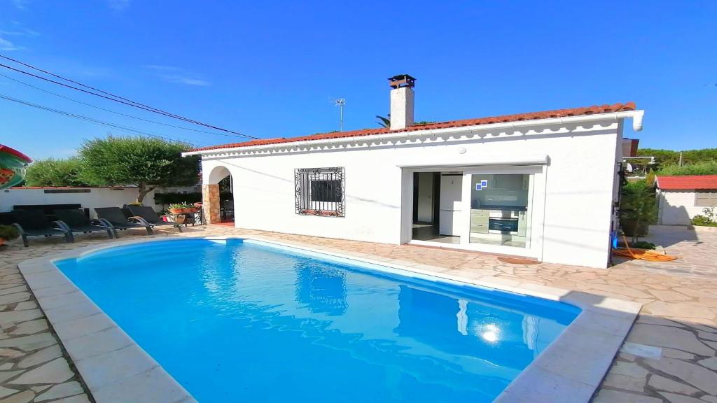 a villa with a swimming pool in front of a house at VACAY Villa Camí in L'Escala