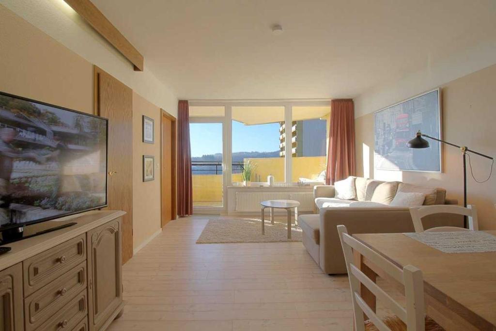 ein Wohnzimmer mit einem Sofa, einem TV und einem Tisch in der Unterkunft Apartment 261 in Hohegeiß