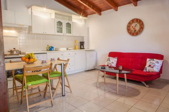 cocina con sofá rojo y mesa en Blue house, en Dhrepanon