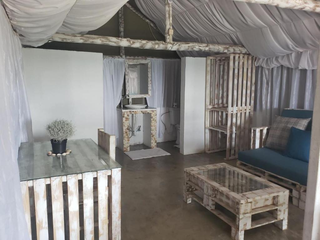 ein Wohnzimmer mit einem blauen Sofa und einem Tisch in der Unterkunft Complexo Baleia Azul Camping in Ponta do Ouro