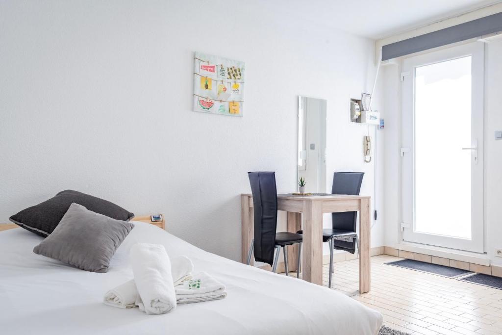 a bedroom with a bed and a table with chairs at Petit Cronenbourg - GOLDEN TREE - WIFI - 5 min gare de Strasbourg in Strasbourg