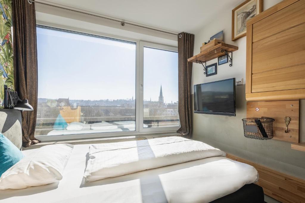 a bedroom with a bed and a large window at Aappartel City Center - kontaktloser Check-in 24h in Bielefeld