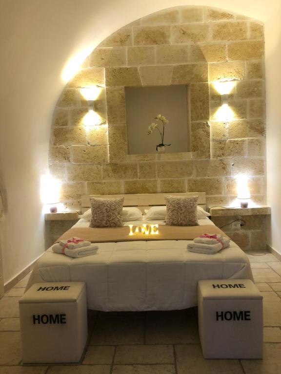 sypialnia z dużym łóżkiem i kamienną ścianą w obiekcie Casetta dello Scrittore w mieście Ostuni
