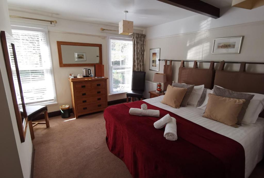 a bedroom with a large bed with two towels on it at The Langstrath Country Inn in Keswick