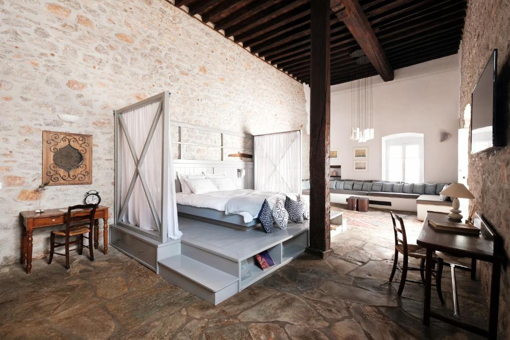 a bedroom with a bed and a table and chairs at Keresbino Hydra Manor House in Hydra
