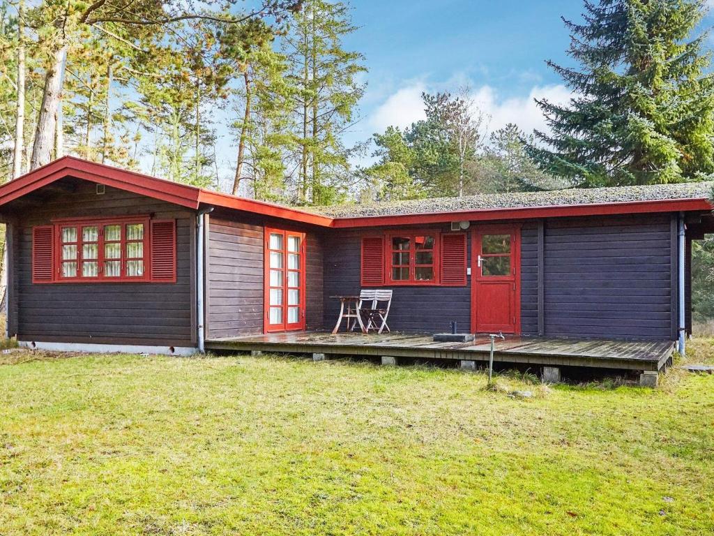 een klein huis met een rode deur in een tuin bij Holiday home Store Fuglede XXI in Store Fuglede