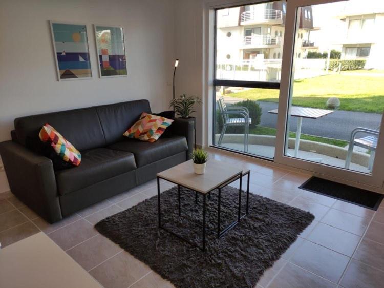 ein Wohnzimmer mit einem Sofa und einem Tisch in der Unterkunft Appartement Biaritz in Bredene