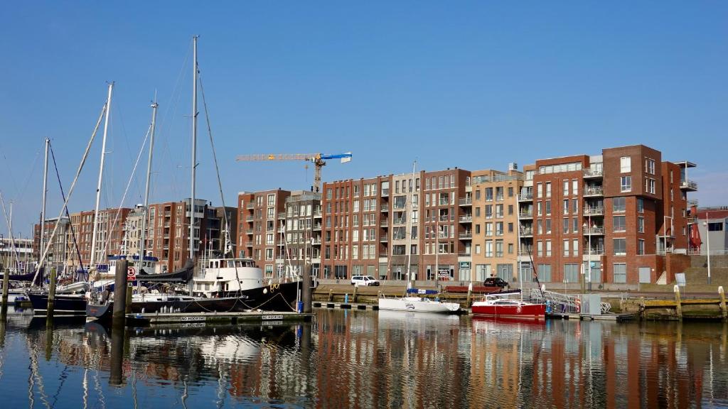 eine Gruppe von Booten, die in einem Yachthafen mit Gebäuden angedockt sind in der Unterkunft BizStay Harbour I Scheveningen Apartments in Scheveningen
