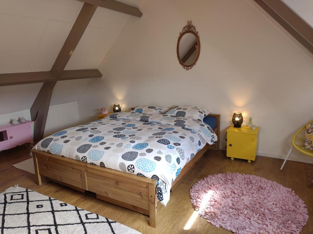 1 dormitorio con cama, espejo y alfombra en 't KISTJE Bed by the Sea, en Koudekerke