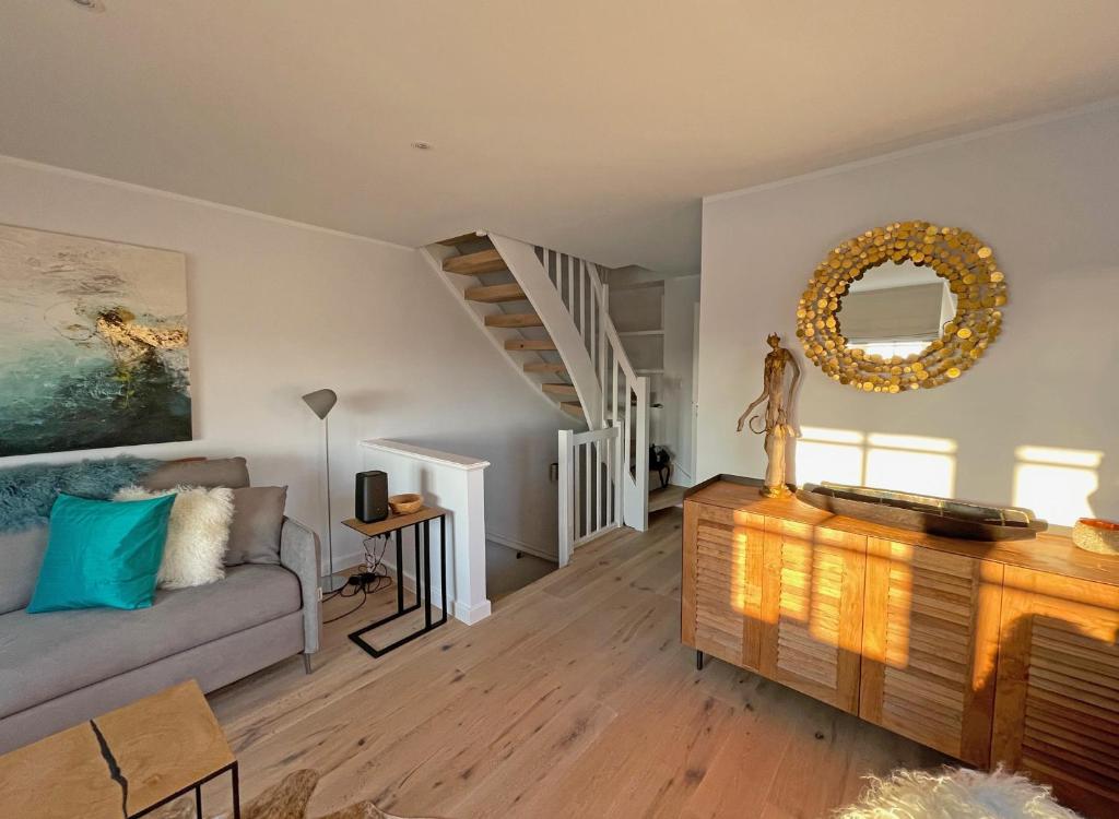 a living room with a couch and a staircase at Wattteufel Sylt in Rantum