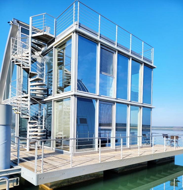 a house on the water with a staircase at schwimmende Ferienwohnung Rooftop in Elsterheide