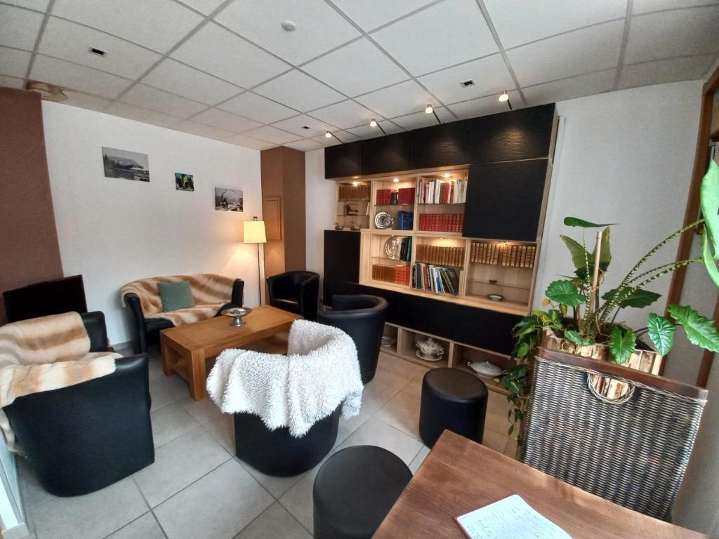 ein Wohnzimmer mit einem Tisch und einem Sofa in der Unterkunft Hôtel *** Les Tremplins in La Chaux Neuve