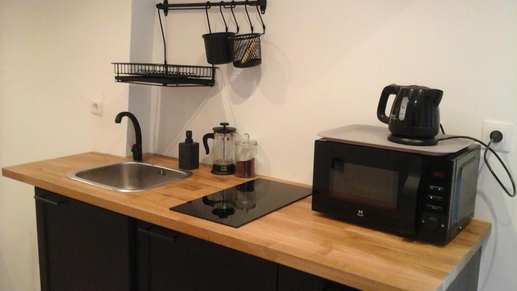 a kitchen counter with a microwave and a sink at Kira in Uzès