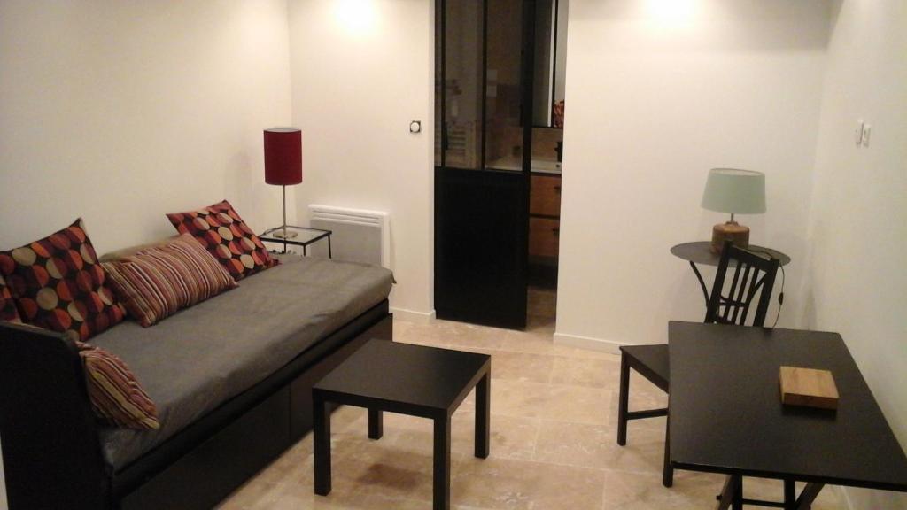 a living room with a couch and two tables at Kira in Uzès