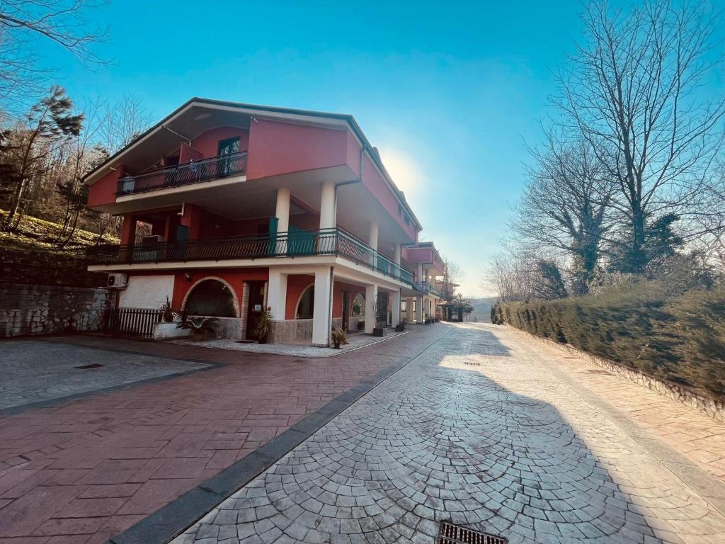 ein rotweißes Gebäude auf einer Backsteinstraße in der Unterkunft Pietrabianca Country House in Manocalzati