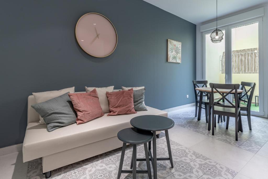 Chic & Comfortable Apartment, Private Terrace في فالنسيا: غرفة معيشة مع أريكة وساعة على الحائط