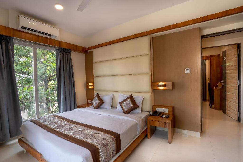 a bedroom with a large bed and a window at Home2 Suites and Service Apartments, Mumbai Airport in Mumbai
