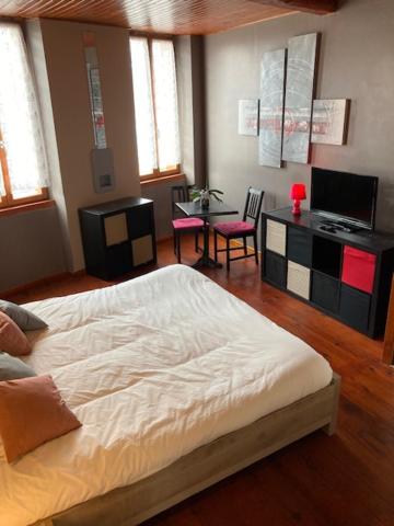 1 dormitorio con 1 cama, mesa y sillas en La patte d'oie, en Rieumes