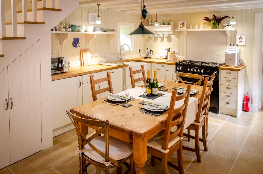 cocina con mesa de madera y sillas en Kirk Wynd Cottage, en Kirriemuir