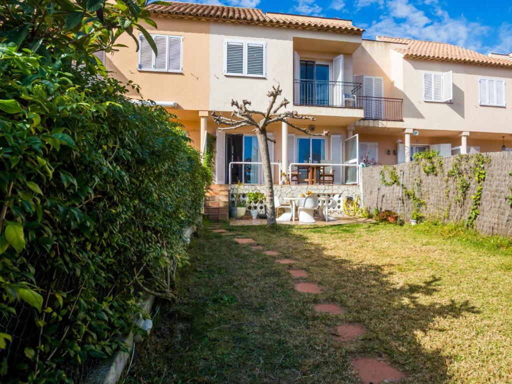 uma villa com uma sebe em frente a uma casa em Casa brisa em Sant Feliu de Guíxols