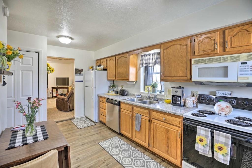 eine Küche mit Holzschränken und einem weißen Kühlschrank in der Unterkunft Akron Apartment with Balcony - Hunting Nearby! in Akron