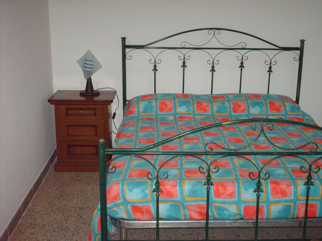 sypialnia z łóżkiem i komodą z narzutą w obiekcie B&B Le Caselle w mieście Tarsia
