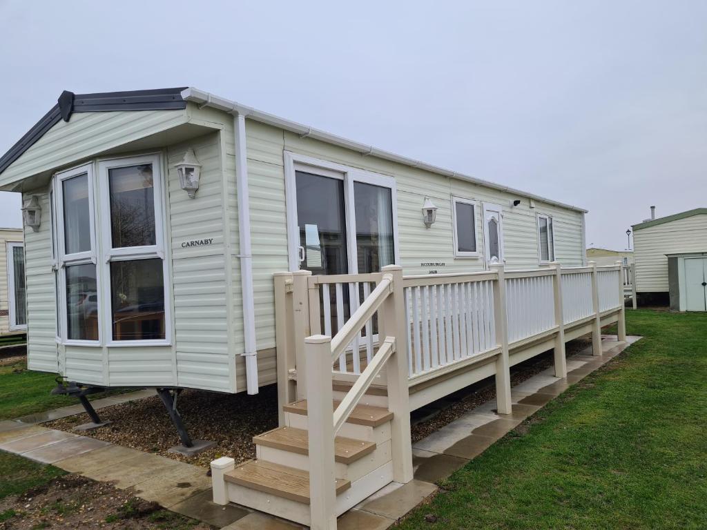 a tiny house with a porch and a deck at 6 Berth central heated on The Chase Roxburgh FREE WIFI in Ingoldmells