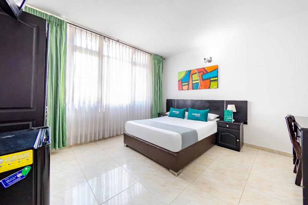a bedroom with a bed and a television in it at Ayenda Imperio la 16 in Pereira