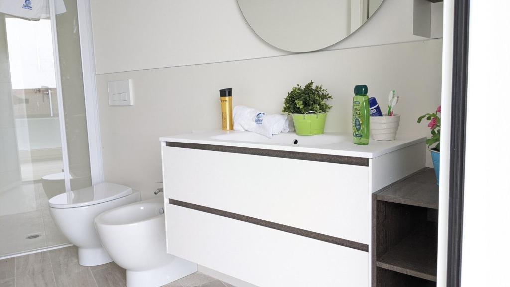 a bathroom with a white sink and a toilet at Zero5.Zero5 in Lignano Sabbiadoro