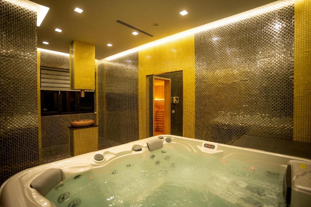 un bagno con una grande vasca in una stanza di Deluxe Resort and SPA a Shkodër