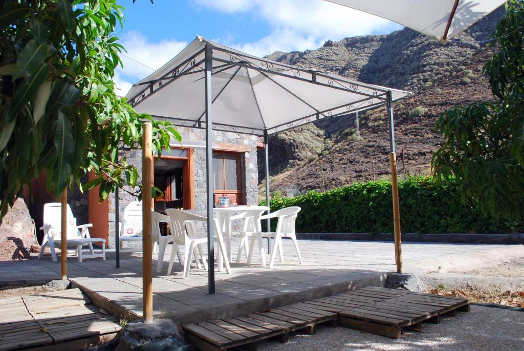 a patio with a table and chairs and an umbrella at Casa Dos Barrancos C - Un Dormitorio, Parque Rural de Anaga in Santa Cruz de Tenerife