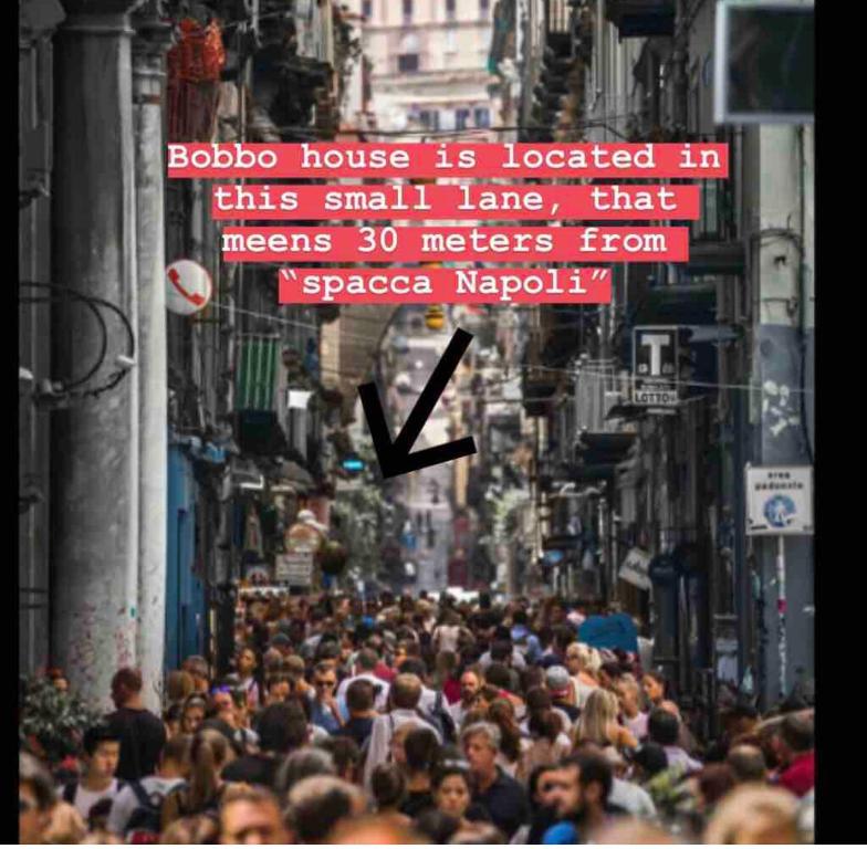 a crowd of people walking down a busy city street at Bobbò house in Naples