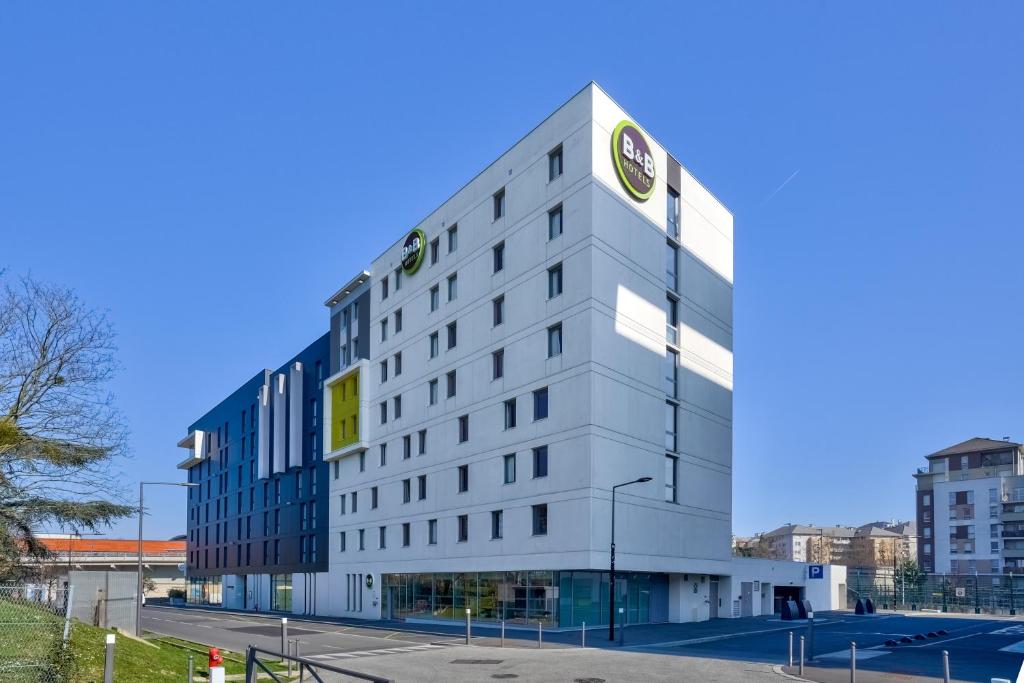 Un bâtiment blanc avec une horloge en haut dans l'établissement B&B HOTEL Paris Créteil, à Créteil