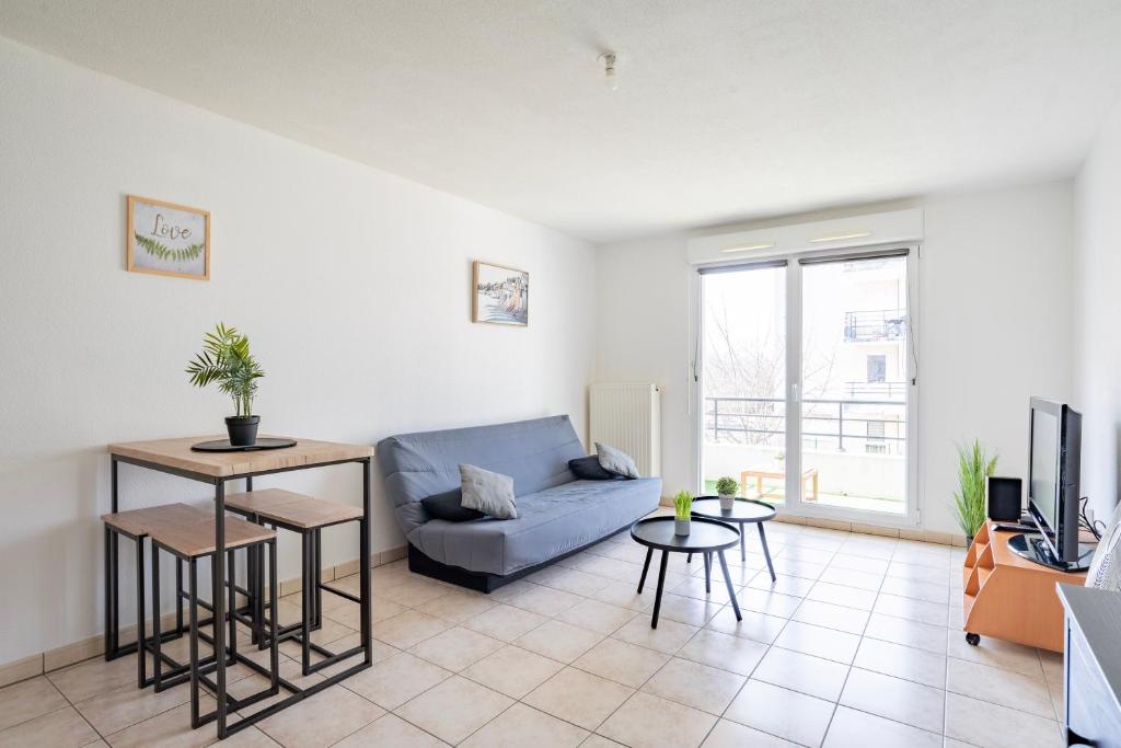 a living room with a couch and a table at Le Zénith - GOLDEN TREE - Parking privé & WIFI - 5 min Zénith de Strasbourg in Strasbourg