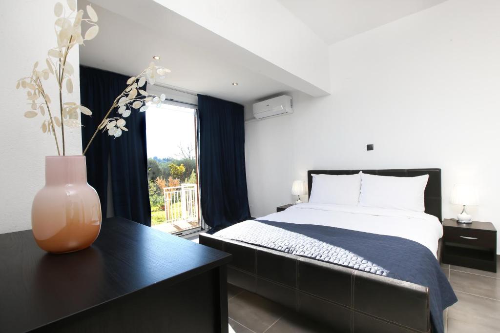 um quarto com uma cama e um vaso sobre uma mesa em Luxury Apartments Christos em Gouvia