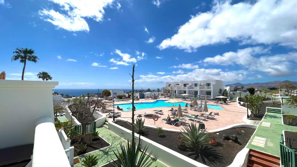 een uitzicht op het zwembad van een resort bij Casa Zen, 1 bedroom apartment on complex with pool, Puerto del Carmen in Puerto del Carmen