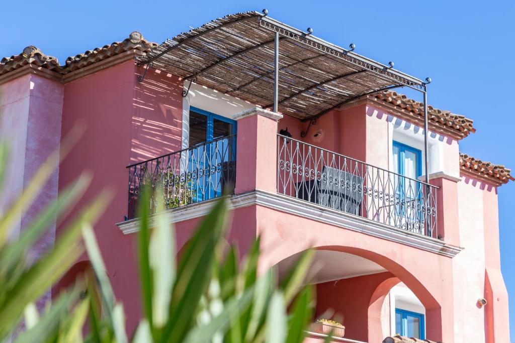 Cette maison rose dispose d'un balcon. dans l'établissement H14 Porto Frailis, à Àrbatax